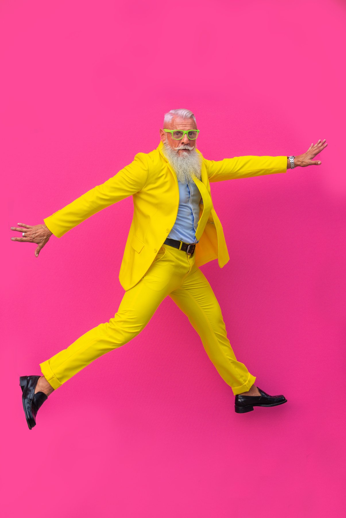 Jumping Senior Man Wearing Bright Yellow Suit